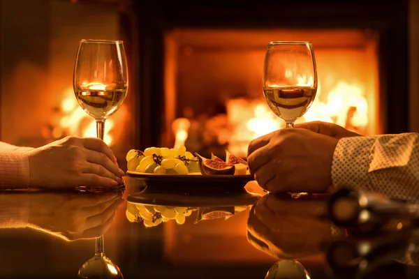 Jovem casal tem jantar romântico com vinho sobre fundo lareira . — Fotografia de Stock