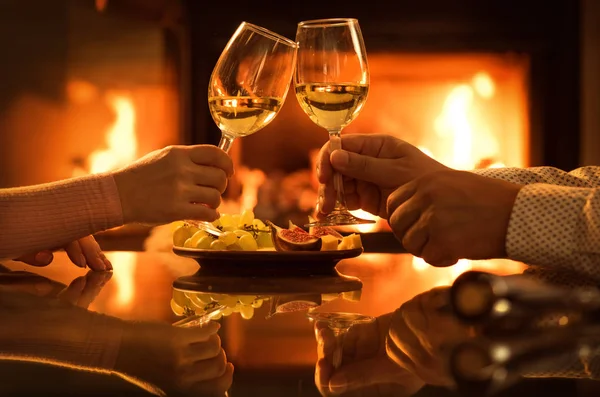 Jovem casal tem jantar romântico com vinho sobre fundo lareira . — Fotografia de Stock