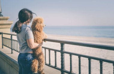 Kumsalda köpeğiyle genç bir kadın. .