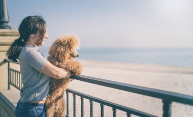 Kumsalda köpeğiyle genç bir kadın. .