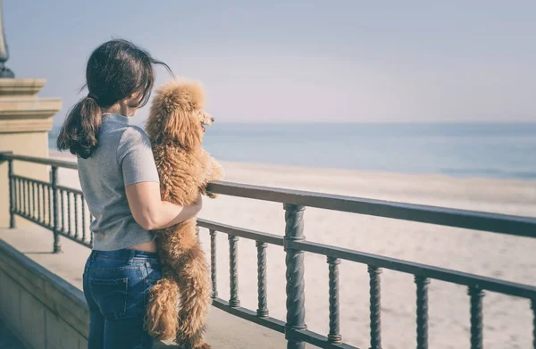 Ung kvinna med sin hund på stranden . — Stockfoto