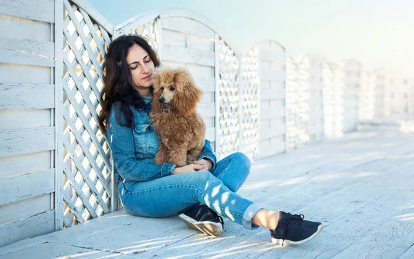 Kvinna med hennes hund på träterrassen . — Stockfoto