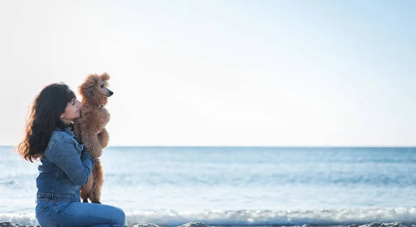 Kobieta z psem o piaszczystej plaży . — Zdjęcie stockowe
