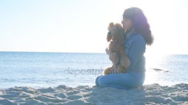 Kadın köpeğini kumlu deniz Beach ile . 
