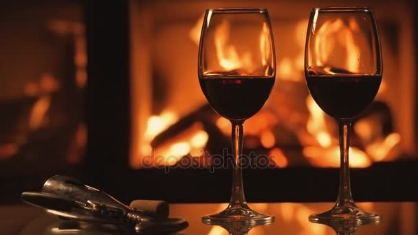 Cinemagraph - Two red wine  wineglasses over fireplace background. — Stock Video
