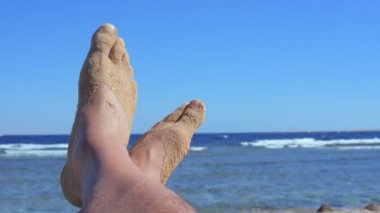 Adamın bir plajda çıplak ayak.