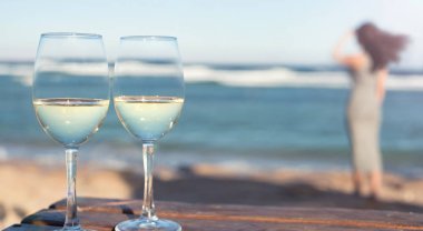 İki beyaz şarap kadehlerin deniz arka plan üzerinde. Sahilde tatil tropikal.