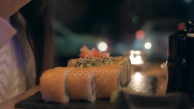 Genç kadın suşi şehir restoranda yemek suşi bar. Akşam yemeği. 