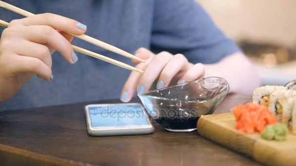 Weibliche Hand Tippt Auf Touchscreen Handy Und Legt Dann Sushi — Stockvideo