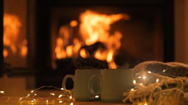 Bir bardak sıcak kakao şömine arka plan üzerinde ile gelen buhar. Dekorasyon çelenk ışık . 