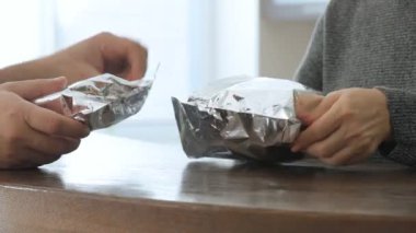 Erkek ve kadın el karton kutular hamburger ile açın. Hamburger teslim. 