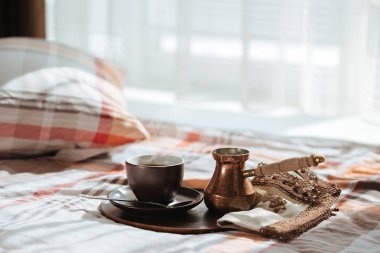 Yatakta bir bardağa lezzetli kahve tepsisiyle.