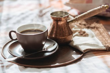 Yatakta bir bardağa lezzetli kahve tepsisiyle.