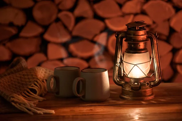 Antyczna Lampa Olejowa Kubki Gorącą Herbatą Tle Drewna Opałowego — Zdjęcie stockowe