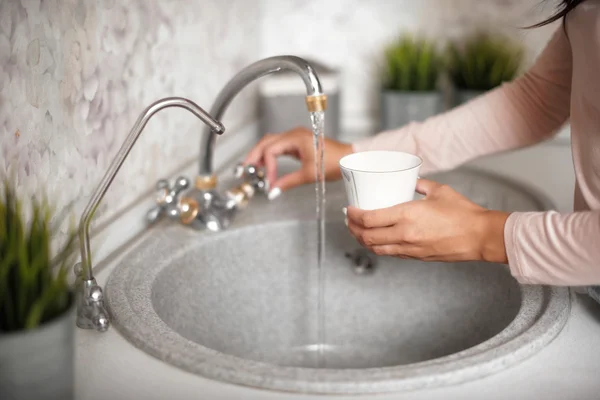 台所の流しの上の女の手洗浄カップ — ストック写真
