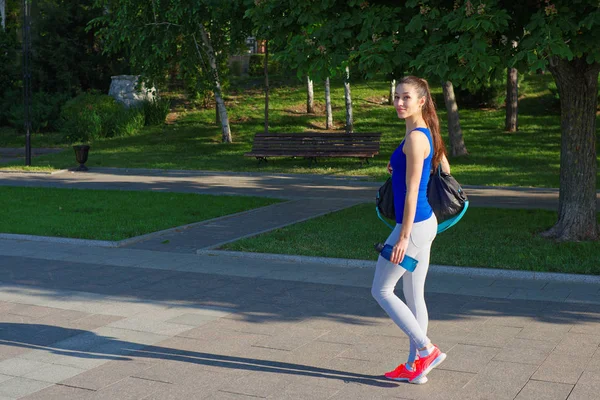 Young woman athlete walking the footpath in the park — Stock Photo, Image