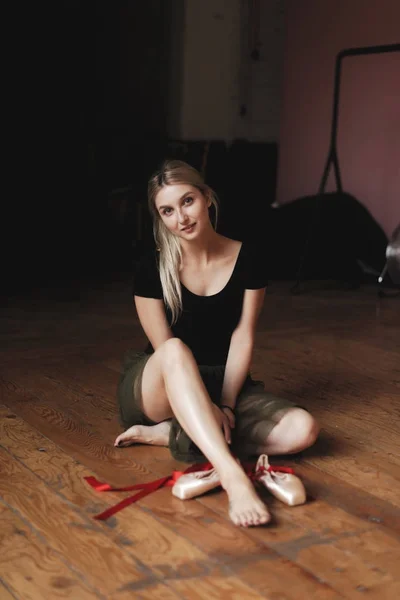 Beautiful ballerina sitting on floor