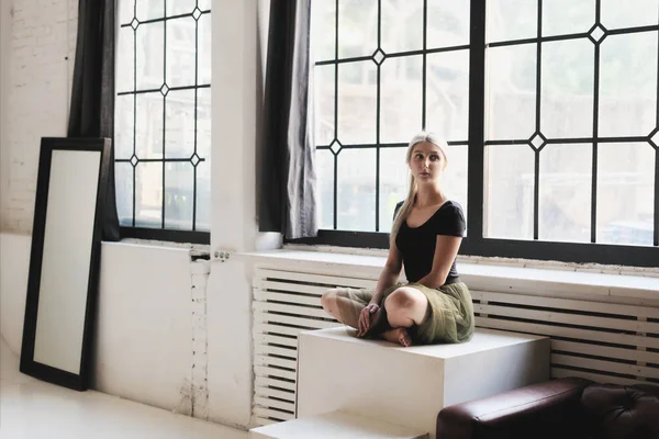 Ballerina sitting near window