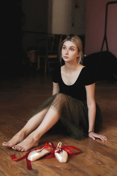 Beautiful ballerina sitting on floor