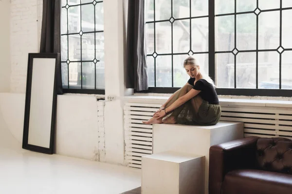 Ballerina sitting near window