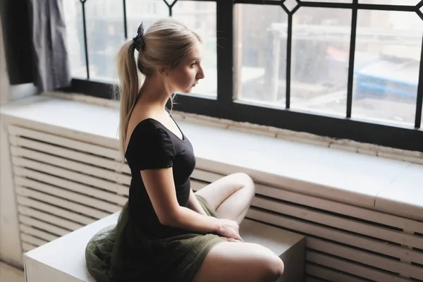 Ballerina sitting near window