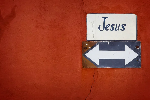 Jesus arrow sign on cracked wall Stock Picture
