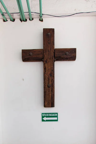 Crucifix dengan tanda rute evakuasi di dinding beton — Stok Foto