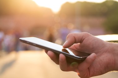 Adam cep telefonunu açık havada kullanıyor, kapat.