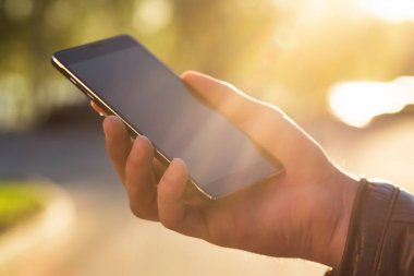 Adam cep telefonunu açık havada kullanıyor, kapat.