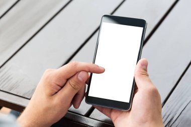 Akıllı cep telefonu ahşap masa arka planda tutan adam