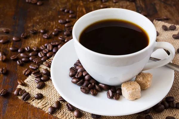 Coffee cup with coffee beans and sack background — Stock Photo, Image