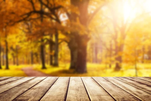 Old wooden desk top with golden leaves — Stock Photo, Image