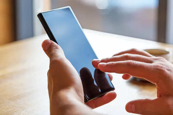 Primer plano de las manos del hombre sosteniendo el teléfono inteligente móvil con co en blanco — Foto de Stock