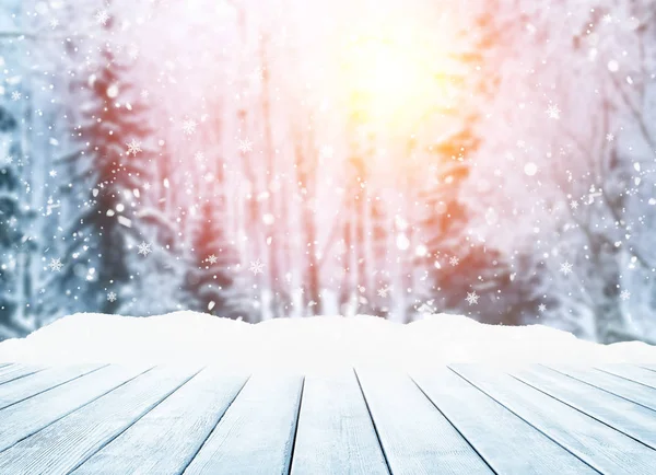 Holztischplatte auf wintersonniger Landschaft mit Tannen. Stockbild