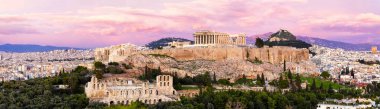 Atina Panoraması ve Akropolis tepesi dramatik günbatımında, Yunanistan. Atina Akropolü, Atina 'nın yukarısındaki kayalık bir çıkıntıda yer alıyor ve aralarında en ünlüsü Parthenon olmak üzere çok sayıda antik binanın kalıntılarını barındırıyor..