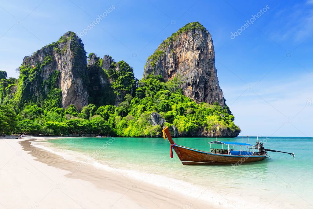 Thai traditional wooden longtail boat and beautiful sand Railay Beach in Krabi province. Ao Nang, Thailand.