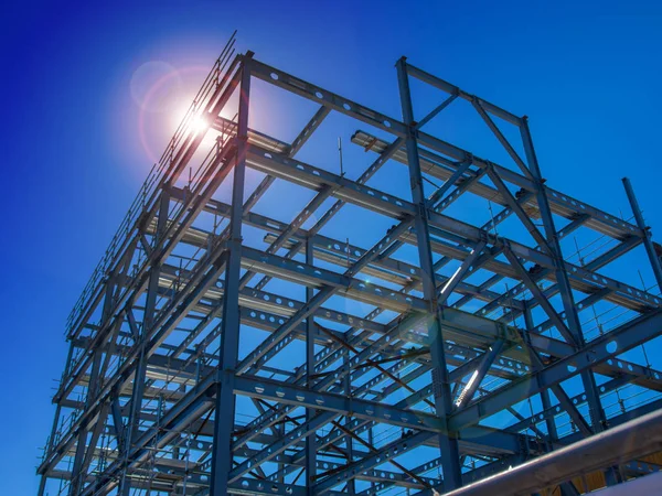 New steel commercial building construction back lit by sun — Stock Photo, Image