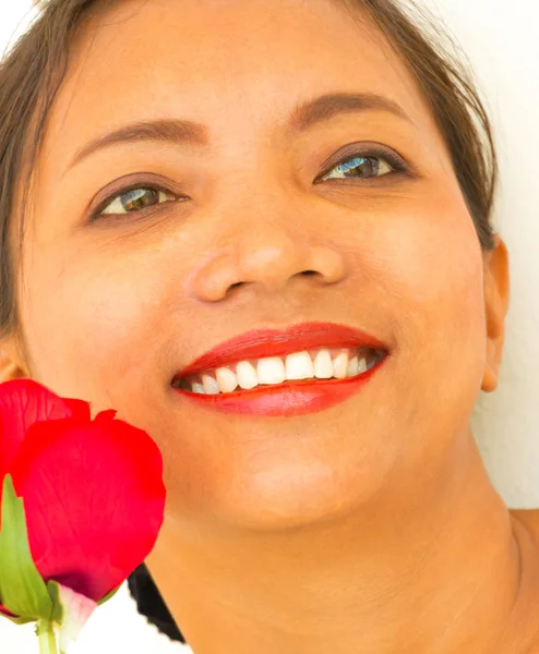 Посміхаючись дівчина з трояндою показує радісне щастя — стокове фото