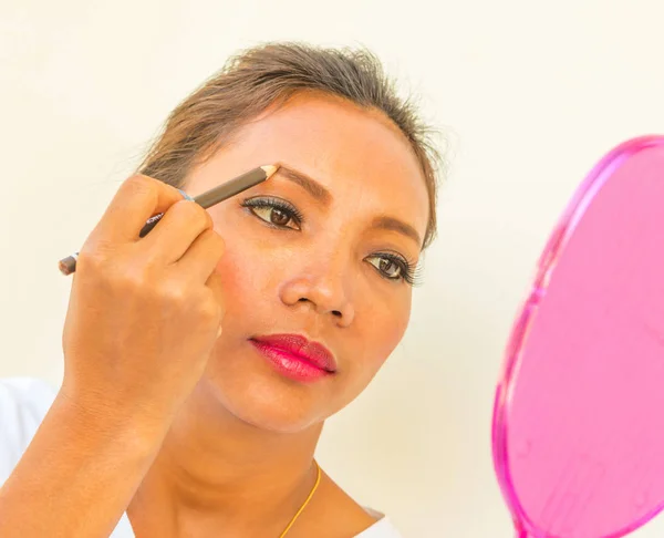 Aplicando sobrancelha maquiagem mostra mulher e cosméticos — Fotografia de Stock