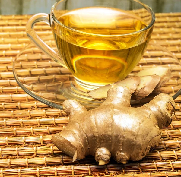 Le thé au gingembre rafraîchissant montre une tasse de thé rafraîchie et des tasses de thé — Photo