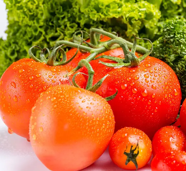 Verse rode tomaten en groene salade in de keuken — Stockfoto