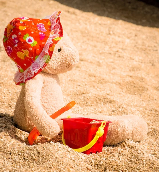 Orsacchiotto con cappello seduto sulla spiaggia — Foto Stock
