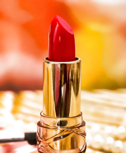 Punainen huulipuna meikki näyttää kauneudenhoitotuotteet ja kosmetiikka — kuvapankkivalokuva