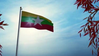 Myanmar bayrağı güneşli ağaçların arasında dalgalanıyor. Bayrak direğindeki arka ışıklandırılmış Burma amblemi özgürlüğü gösteriyor - 3D animasyon