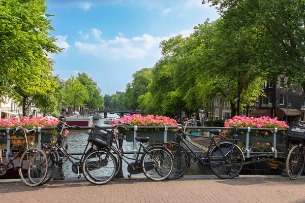 Amsterdam escena del canal con bicicletas y puente —  Fotos de Stock