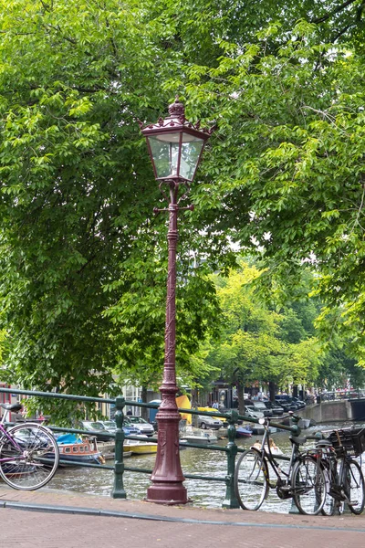 Amsterdam escena del canal con bicicletas y puente — Foto de Stock