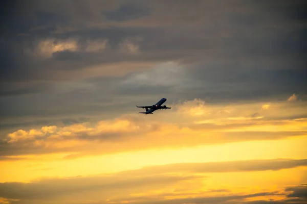 Sziluettjét repülőgép naplementekor — Stock Fotó