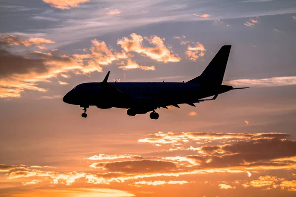 Airplane landing at sunset — Stock Photo, Image