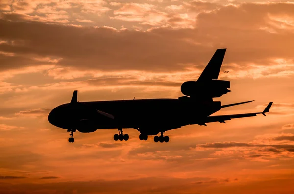 Airplane landing at sunset — Stock Photo, Image