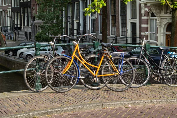 Amsterdam canal scene with bicycles and bridge — Stock Photo, Image